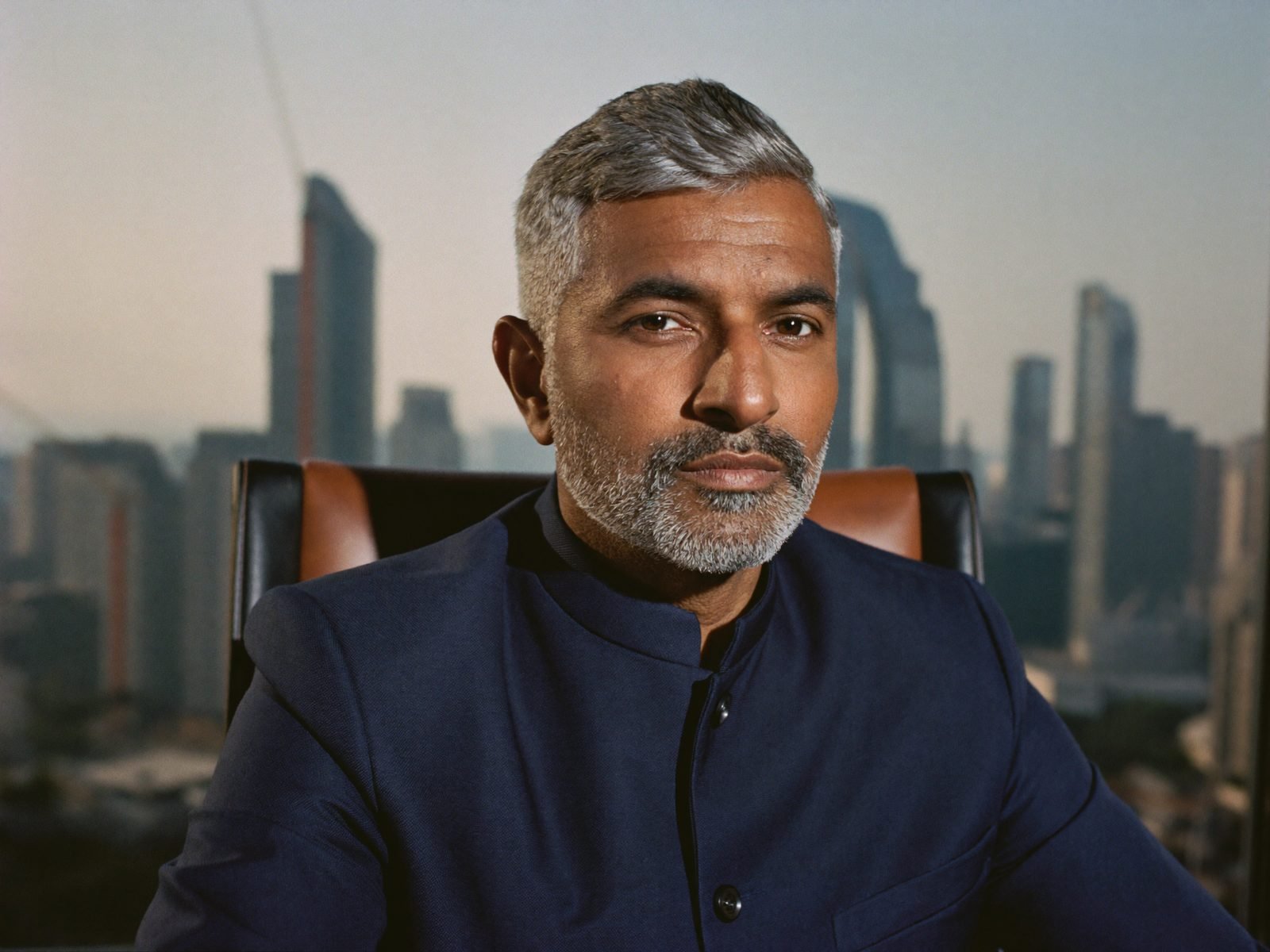 Portrait of a senior Indian founder in a bandhgala, Bengaluru skyline behind him