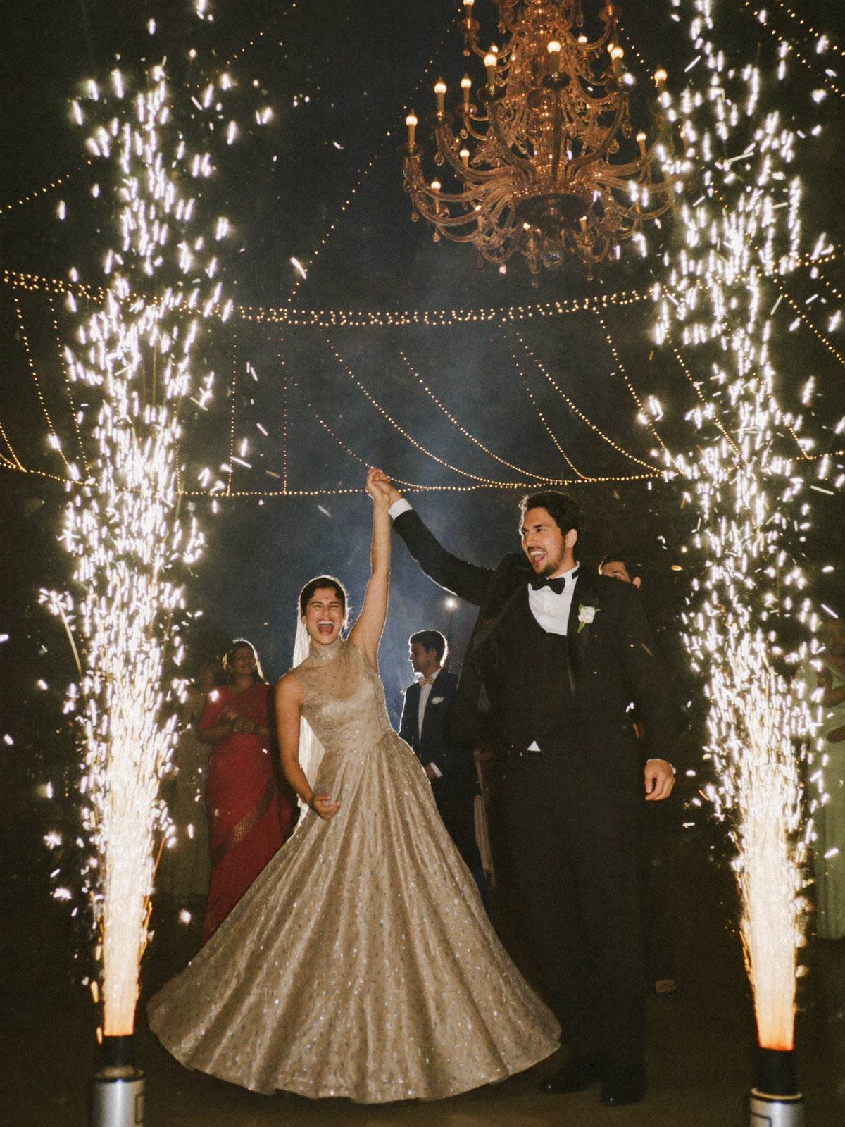 Couple's first dance framed by cold pyro fountains at a grand Indian wedding reception